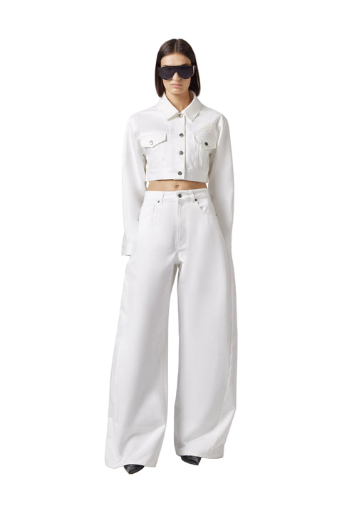 Person wearing a white outfit with sunglasses on a plain background