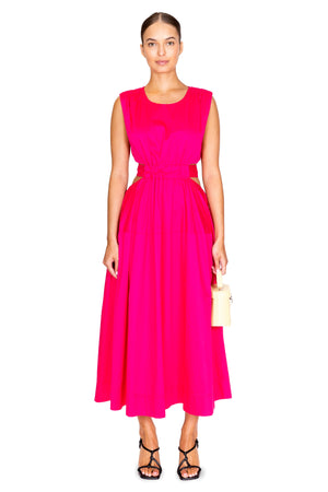 Model facing camera wearing the zorina tie midi dress in hot pink.