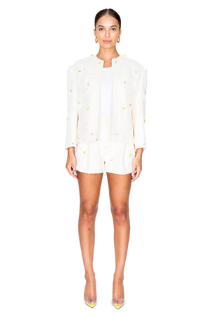 Model wearing the ivory mini flower tweed jacket with pockets.