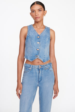 Up close of model wearing the denim vest in mid blue.