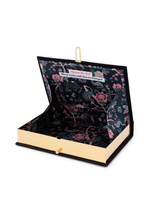 A book clutch with a black floral velvet interior and a gold-tone metal clasp, shown open on a white background.