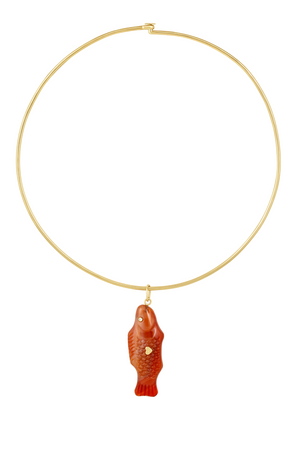 A gold wire necklace with a carnelian agate pendant shaped like a 'Swedish Fish' with two gold hearts on the back.
