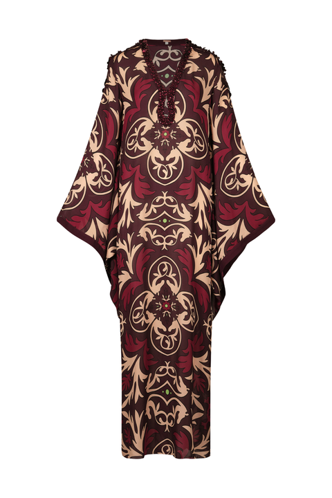 A long, loose kaftan dress featuring an intricate pattern in deep burgundy red and beige, displayed against a solid white background.