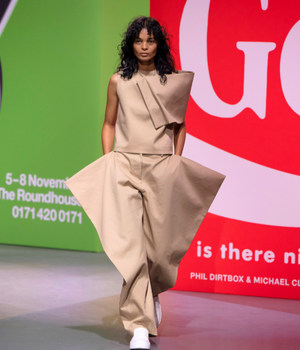 Model walking the runway in the sleeveless kite tip in khaki.