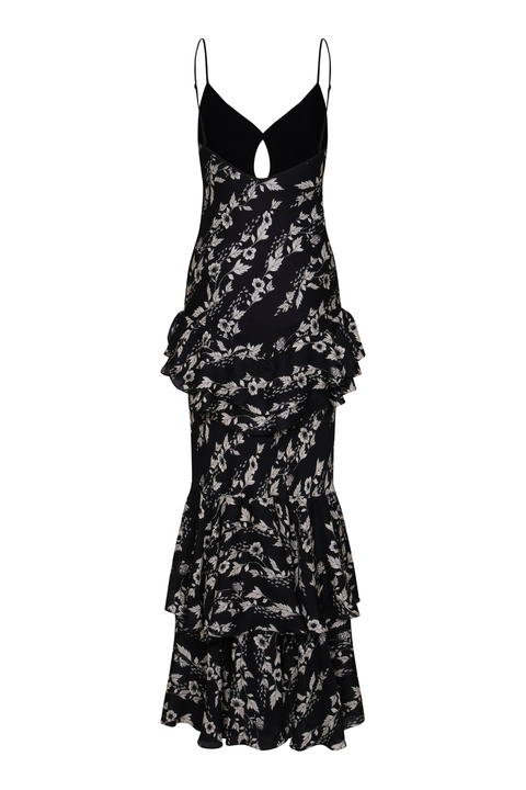 A black maxi slip dress with a white floral print, featuring thin spaghetti straps, a plunging neckline with a keyhole cutout, and a tiered ruffle skirt.