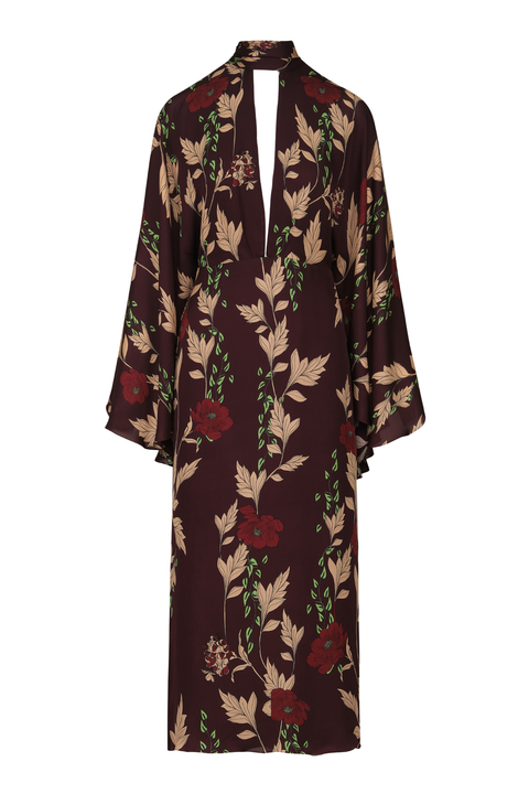 A long-sleeved maxi dress with a dark brown base and an all-over floral print featuring beige leaves, red flowers, and green stems, shown against a plain white background.