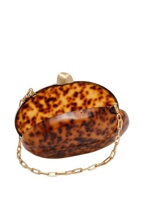 Oval tortoiseshell clutch bag with gold closure and gold strap chain close up