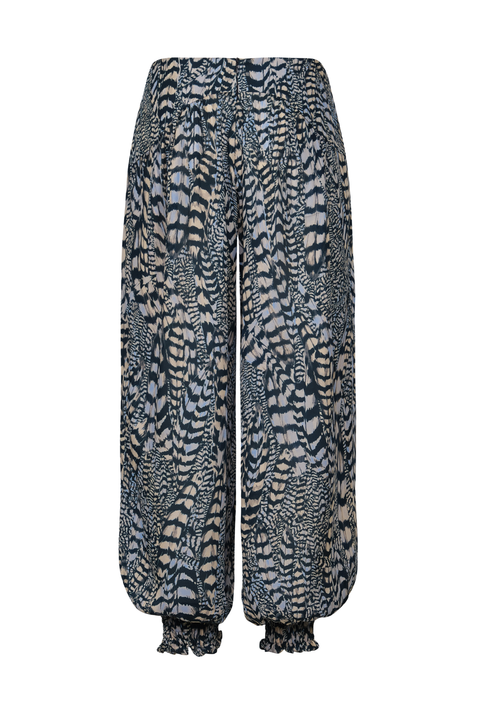 A pair of loose, wide-leg pants featuring an abstract, wavy zebra-like pattern in navy blue, gray, and beige, with gathered elastic cuffs at the ankles.