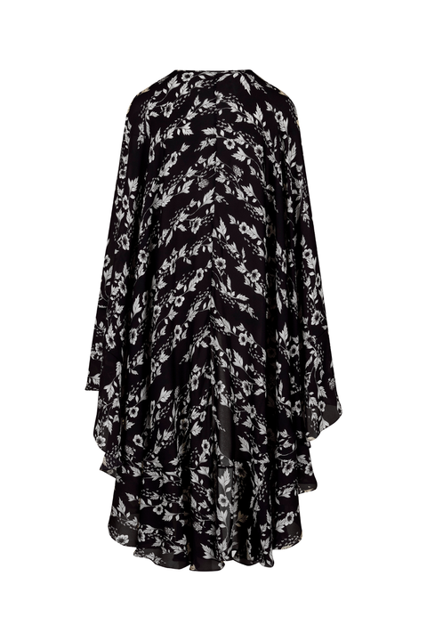 A black long-sleeve cape-style top with a white floral and chevron-like abstract print, shown against a plain white background.