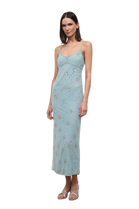A woman wearing a light blue long dress with silver embellishments