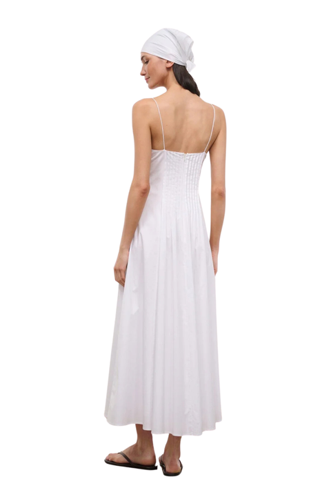 A woman shown from the back wearing a white spaghetti-strap maxi dress with a smocked bodice and a matching white headscarf, standing against a plain white background.