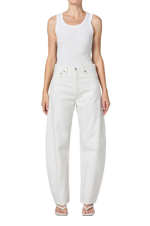 Person wearing white mid-rise jeans and a white tank top on a white background facing forward