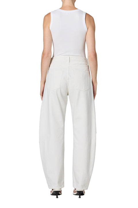 Person wearing white mid-rise jeans and a white tank top on a white background from the back