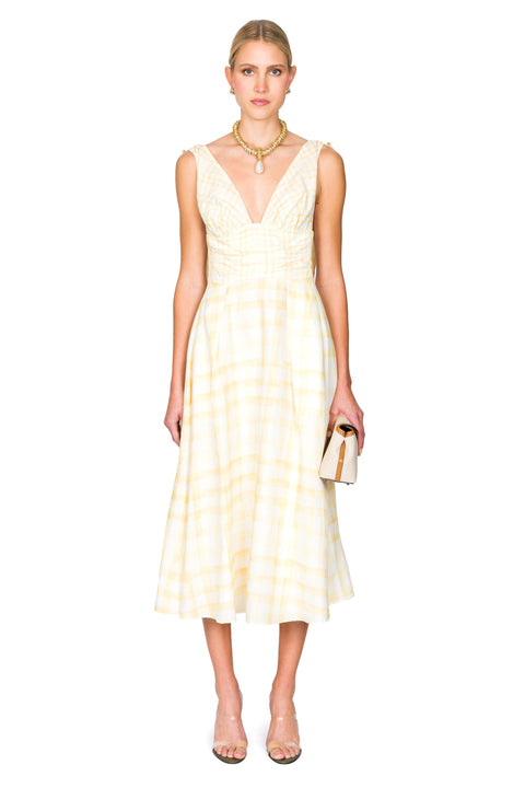 Woman wearing a yellow midi dress with a white background