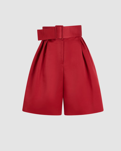 Red wide leg shorts with a belt on a light gray background