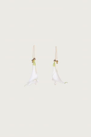 Ghost image of two white calla lily inspired earrings on a gold threader chain.