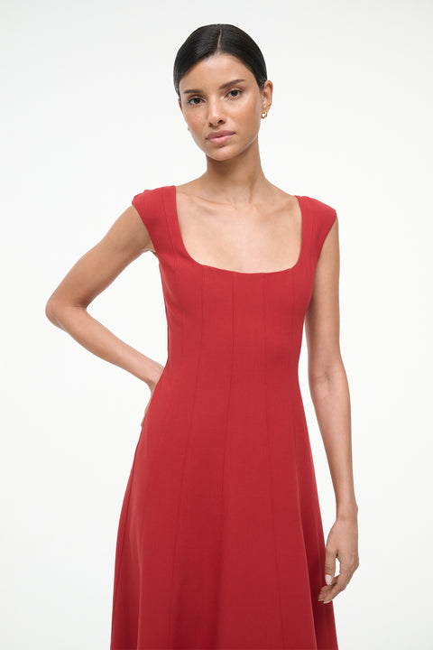 Close up of a woman wearing a red sleeveless midi dress.