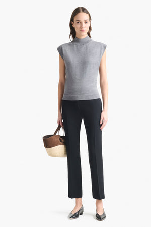Woman wears grey cap sleeve turtleneck sweater top with black pants.