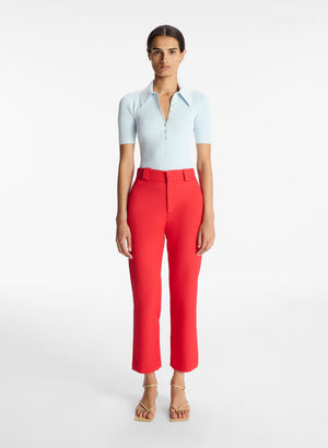 Model facing the camera in the red straight leg pants