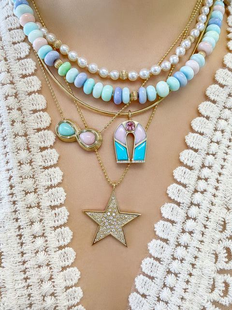 Necklace with star pendant and colorful beads on a textured beige background