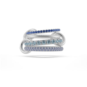 Ghost image of a Spinelli Kilcollin Iris ring that features one 1.7mm sterling silver band pave with blue sapphires, one 2.3mm sterling silver band, one 2.8mm sterling silver band pave with aquamarine, and one 2.8mm sterling silver band pave with tanzanite, all connected by three sterling silver connectors.