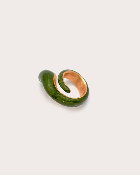 Green and gold earring on a light gray background