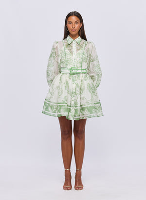 Model facing forward wearing the cassandra belted mini dress in green print.