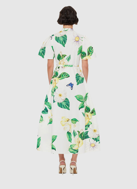 Woman facing away in white midi dress with floral print.
