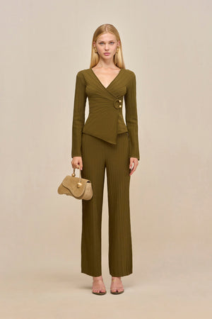 Woman wearing green ribbed wide leg pants with a matching wrap top, paired with a tan handbag.
