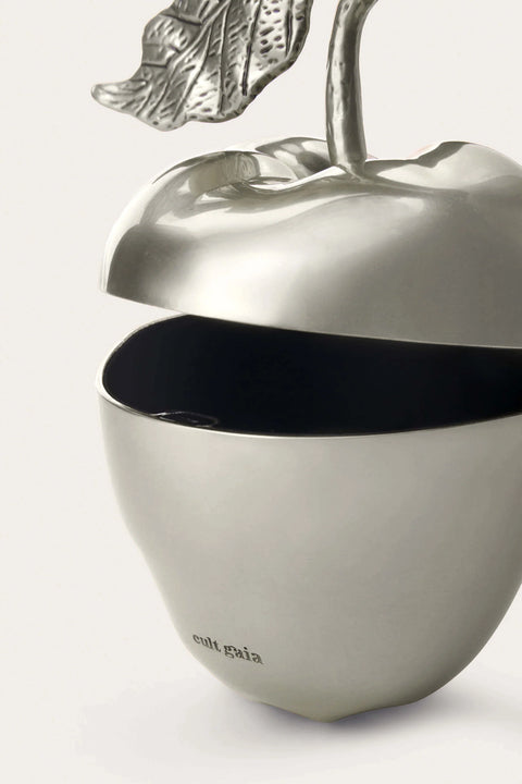 Silver apple-shaped bag opened up with a leaf on a white background
