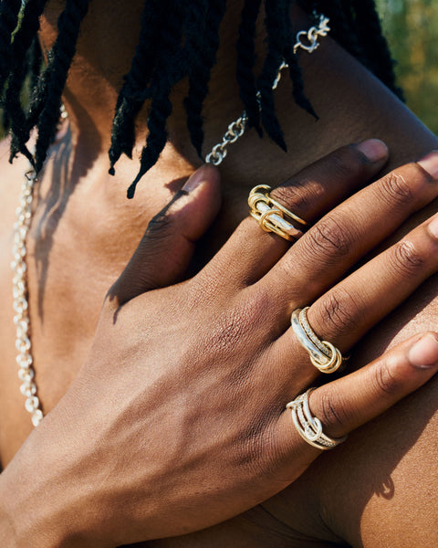 A man wearing three Spinelli Kilcollin rings: a Sonny SG Gris; a Gemini SG Vulcan, and an Osric SG Gris.