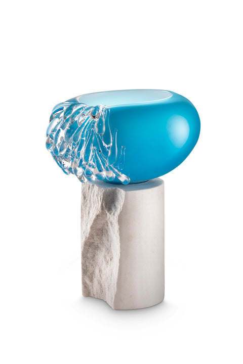 Blue and clear glass art piece on marble base.