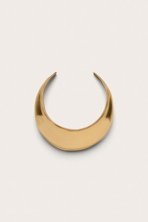 A sculptural gold-toned choker that features a think beveled edge and an open back.