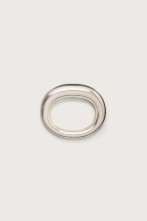A silver toned tubular bangle that features an asymmetrical thicker side.