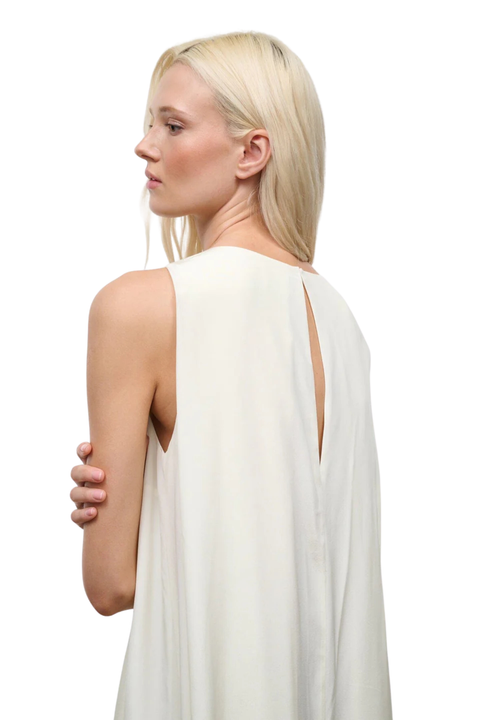 Woman wearing a white sleeveless maxi dress on a white background close up