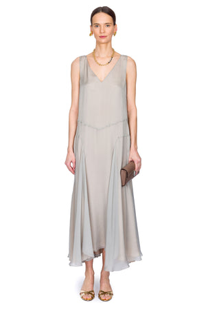 Woman wearing a light gray dress on a white background