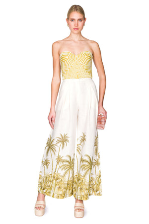 Strapless yellow bustier top with white piping and white linen palazzo pants with palm tree patterning
