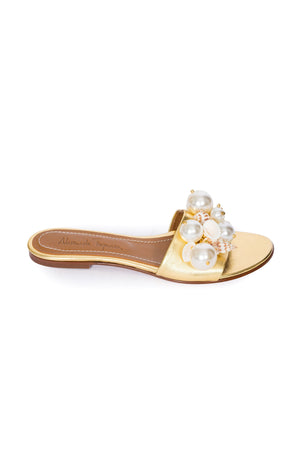 Gold sandal with pearl and shell embellishments on a white background