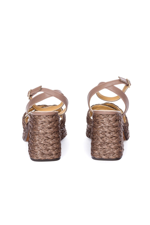 Back view of brown woven sandal with a platform sole on a white background