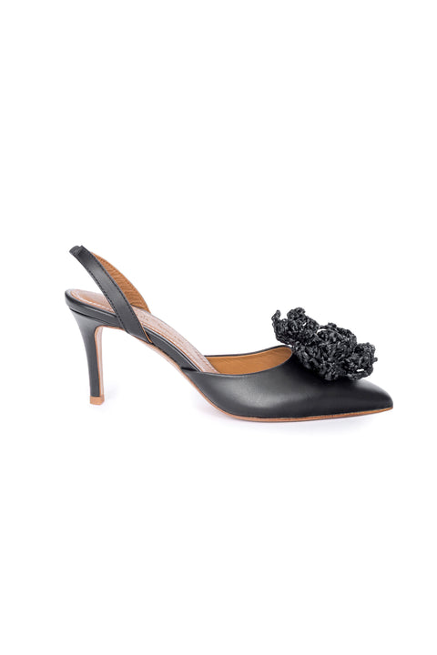 Black high-heeled shoe with floral embellishment on a white background
