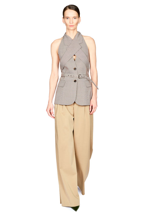 A model wearing a sleeveless gray belted wrap-style blazer with a keyhole cutout and beige wide-leg trousers, photographed against a plain white studio background.