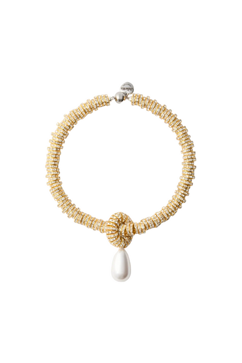 Gold beaded necklace with a white pendant on a light gray background