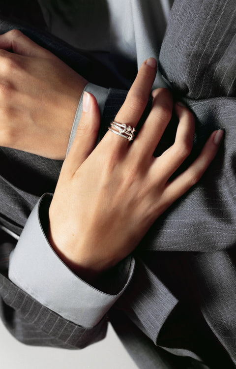 A woman's hand wearing a Spinelli Kilcollin Raneth ring in all sterling silver.