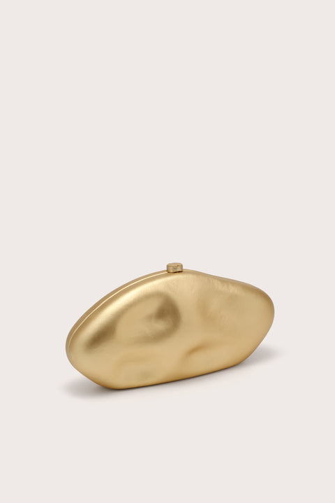 A side-facing gold, oval-shaped sculptural clutch. 