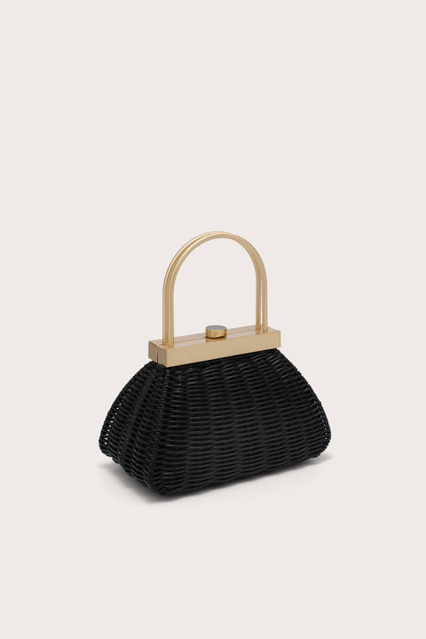 Black woven handbag with a gold handle on a beige background