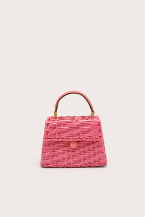 A pink wicker, trapezoidal handbag that features a top handle and flap closure, complete with gold-toned hardware. 