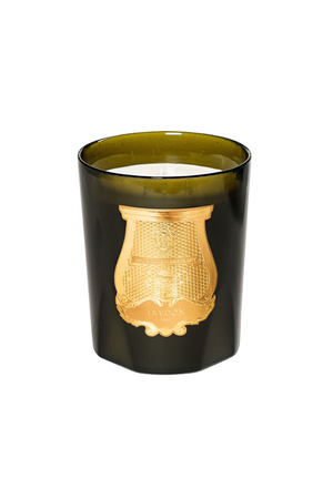 An amber green murano glass jar candle with a prominent gold crest emblem on the front, set against a plain white background.