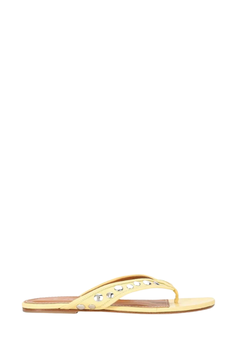 A single pale yellow flat thong sandal with silver rhinestone embellishments along the strap, shown from a side profile on a plain white background.