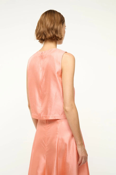 Back view of a woman wearing a pink silk tank top that features a crewneck and boxy fit, paired with a matching maxi skirt.