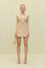Woman wearing a cream knit, long sleeve mini dress that features a plunging wood-beaded detail and a keyhole cutout at the bust. 